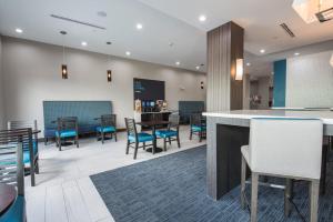 休斯頓的住宿－Holiday Inn Express & Suites Houston - Hobby Airport Area, an IHG Hotel，大堂设有桌椅和酒吧。