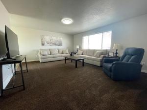 a living room with two couches and a tv at Ray's Place in Roy