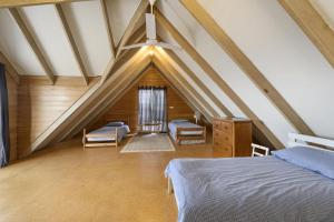 a attic room with a bed and two chairs at Blue Oar Beach House Arrawarra Headland in Arrawarra
