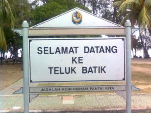 a sign for a teluk bank in a park at Apartment Teluk Batik in Lumut