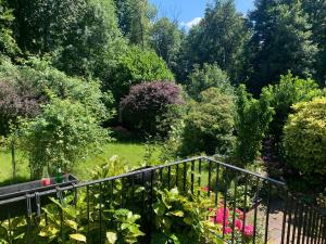 a garden with a fence and flowers and trees at Ferienwohnung & Aparts am Schloss Park in Essen