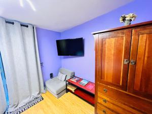 a blue room with a tv and a chair at Tiny House with private Hot Tub near Seattle in Shoreline