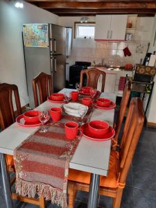 una mesa con platos rojos y copas de vino. en Cabaña Ceferino Ushuaia en Ushuaia