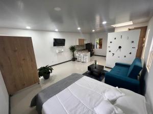 1 dormitorio con 1 cama y reloj en la pared en apartaestudios las astromelias Armenia, en Armenia