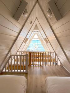 a attic room with two beds and a large window at Duffin Cove Resort in Tofino