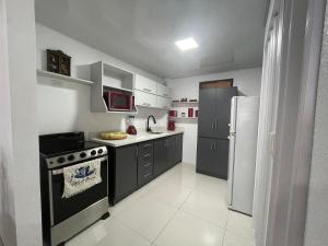 a kitchen with a stove and a refrigerator at Alicia's Place 10 min from AirPort in Alajuela City