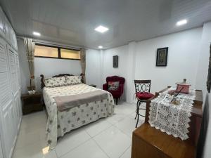 - une chambre avec un lit, une table et une chaise dans l'établissement Alicia's Place 10 min from AirPort, à Alajuela