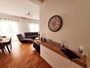 uma sala de estar com um grande relógio na parede em Lovely 2-Bedroom 4th Floor House Large Patio em Atenas