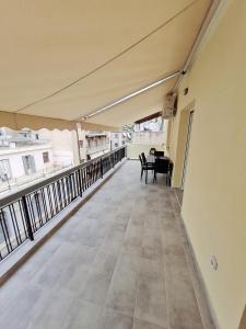 uma varanda vazia de um edifício com uma mesa e cadeiras em Lovely 2-Bedroom 4th Floor House Large Patio em Atenas