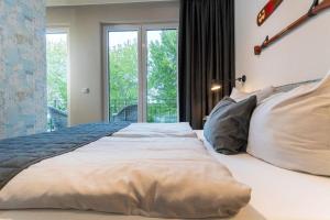 ein großes Bett in einem Schlafzimmer mit Fenster in der Unterkunft Appartmenthaus "Südstrand 44", Wohnung 15 "Abendrot" in Großenbrode