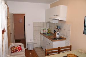 a small kitchen with a sink and a counter at Apartments by the sea Brodarica, Sibenik - 20762 in Šibenik