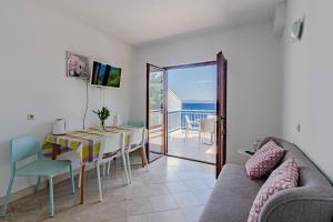 ein Wohnzimmer mit Tisch und Blick auf das Meer in der Unterkunft Apartments by the sea Prigradica, Korcula - 20871 in Blato