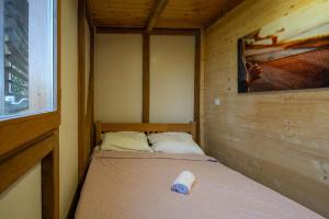 a small bedroom with a bed in a wooden cabin at Secluded fisherman's cottage Cove Babac, Pasman - 20901 in Pašman