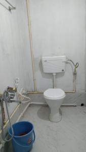 a bathroom with a toilet and a bucket at Damfu Basera Homestay in Kurseong