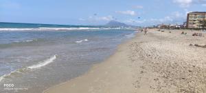 a beach with people walking on the sand and the ocean at Apartamento de 100 M2 con 3 habitaciones y 2 terrazas in El Verger