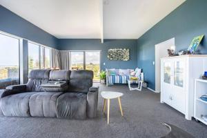 a living room with a couch and a table at Million Dollar Views in Mangawhai