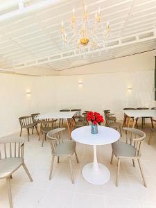 a room with tables and chairs and a chandelier at Baan Suan Rojjana in Muak Lek District