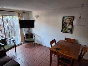 a living room with a table and a tv at Concepción - San Pedro de la Paz in San Pedro de la Paz