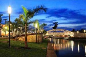 uma palmeira sentada ao lado de um rio à noite em Moderno Departamento Paseo la Cortadura en Tampico em Tampico