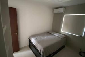 a small bedroom with a bed in a room at Moderno Departamento Paseo la Cortadura en Tampico in Tampico