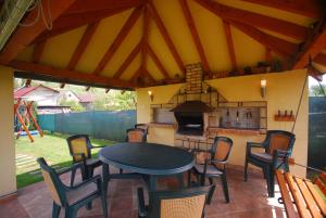 a patio with a table and chairs and a fireplace at Apartman Elegant in Bešeňová