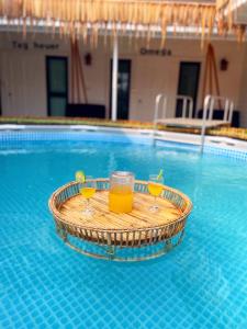 a tray with two glasses of orange juice in a swimming pool at กาลเวลา เกาะสีชัง in Ban Tha Thewawong