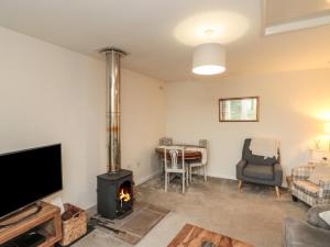 a living room with a fireplace and a tv at Chestnut Cottage in Scarborough