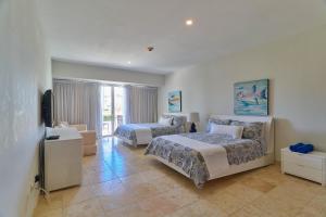 a hotel room with two beds and a television at Relax Beach Condo W Private Pool And Beach! in Punta Cana +41 photos