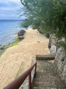 a staircase leading to a sandy beach with the ocean at Pescador View - Beach Resort & Restaurant in Moalboal