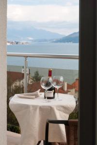 a table with a bottle of wine and two glasses at Guest House Aria in Herceg-Novi