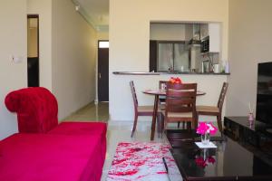 a living room with a red couch and a table at RedFin Vacation Home in Vipingo
