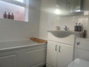 La salle de bains blanche est pourvue d'un lavabo et de toilettes. dans l'établissement Home Sweet Home in RG1 with FREE Parking, à Reading