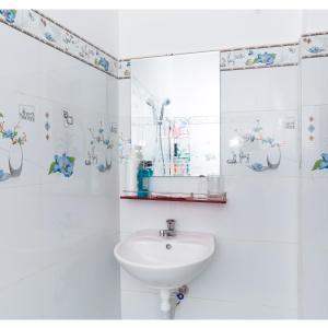 uma casa de banho branca com um lavatório e um espelho em NHÀ NGHỈ & HOMESTAY PHẠM GIA em Vạn Ninh