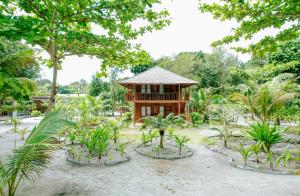 ein kleines Gebäude inmitten eines Gartens in der Unterkunft Leebong Island Resort in Leebong