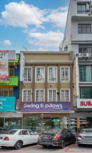 a building with cars parked in a parking lot at Swing & Pillows - Subang SS15 in Subang Jaya