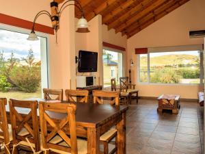 a living room with a table and chairs and a tv at Los Llantenes in San Andres de las Sierras