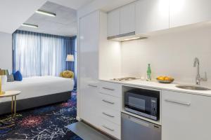 eine Küche und ein Schlafzimmer mit einem Bett und einem Waschbecken in der Unterkunft Naima Hotel in Melbourne