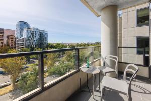 einen Balkon mit einem Tisch und Stühlen sowie Stadtblick in der Unterkunft Naima Hotel in Melbourne