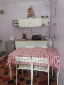 a kitchen with a table with four chairs and a counter at Haji Homestay - A tiny house with 2 bedrooms in Bentong