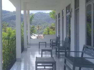 a porch with chairs and a view of the mountains at Hidayah homestay in Kelimutu