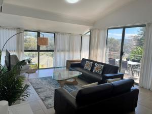 a living room with a couch and a glass table at Avoca Palms Resort in Avoca Beach