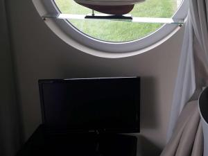a television in a room with a round window at Rez-de-chaussée avec terrasse, parking, animaux acceptés près de la mer - FR-1-675-15 in Wimereux