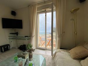 salon z łóżkiem i dużym oknem w obiekcie Appartement spacieux face plage avec balcon, parking privé et animaux admis à Trégastel - FR-1-368-378 w mieście Trégastel