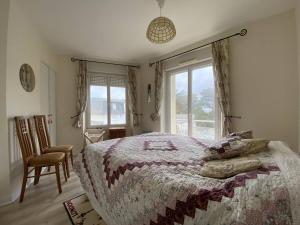 sypialnia z łóżkiem, krzesłem i oknem w obiekcie Appartement spacieux face plage avec balcon, parking privé et animaux admis à Trégastel - FR-1-368-378 w mieście Trégastel