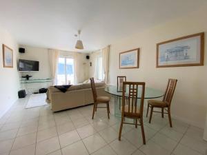salon ze stołem, krzesłami i kanapą w obiekcie Appartement spacieux face plage avec balcon, parking privé et animaux admis à Trégastel - FR-1-368-378 w mieście Trégastel