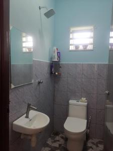 La salle de bains est pourvue de toilettes blanches et d'un lavabo. dans l'établissement Haji Homestay - A tiny house with 2 bedrooms, à Bentong