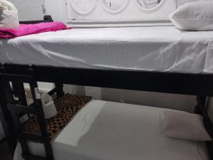 Calvary house في أنتيغوا غواتيمالا: سريرين بملاءات بيضاء ومقعد في الغرفة
