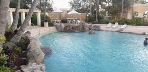 a swimming pool in a resort with chairs and trees at Bellagio@Chevron, Luxe, 2 Bedroom Apartment in the Heart of Surfers Paradise! in Gold Coast