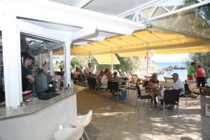 a restaurant with people sitting at tables under yellow umbrellas at Hotel Glicorisa Beach in Pythagoreio +85 photos