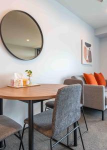a dining room with a table and a mirror at Deluxe One Bedroom Apartment in Newmarket Auckland in Auckland
